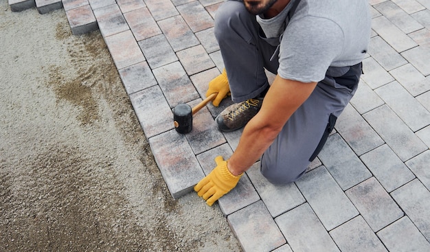 Konzentriert bei der Arbeit Mann in gelber Uniform hat Arbeit mit Pflaster