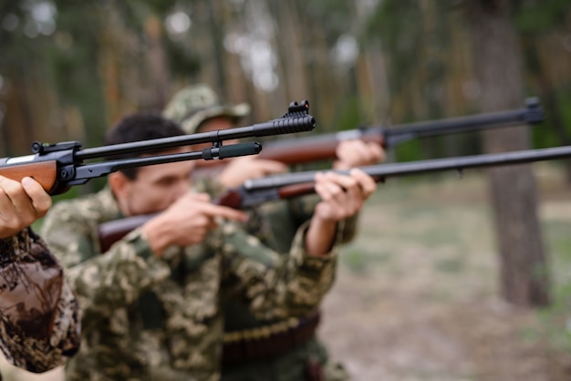 Konzentrierte Jäger, die mit der Gewehr-Vogeljagd zielen.