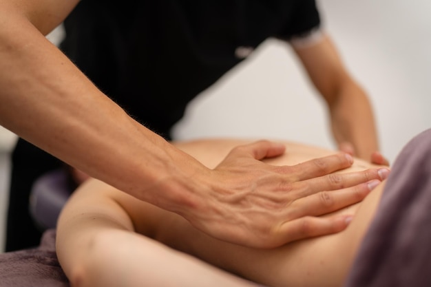 Foto konzentrierte rückenmassage durch eine professionelle masseurin