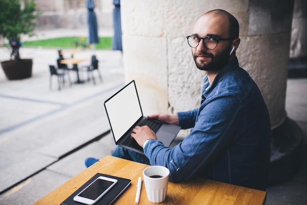 Konzentrierter Mann, der Laptop im Café durchstöbert