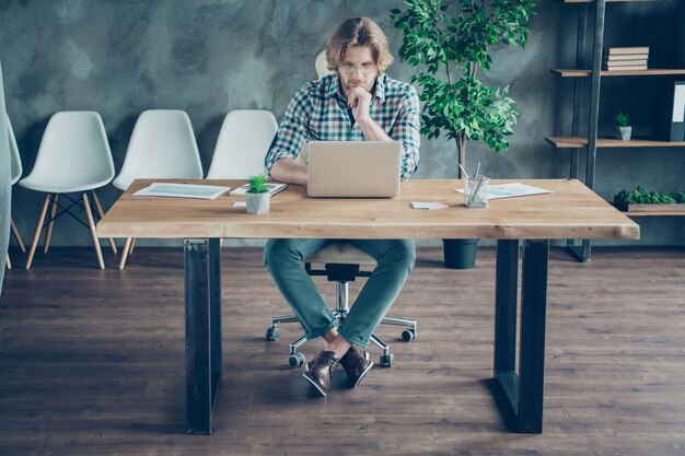 Konzentrierter Mitarbeiter, der im Büro am Laptop arbeitet