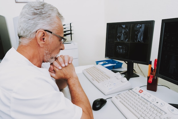 Konzentrierter Radiologie-Doktor Examining CT Scans