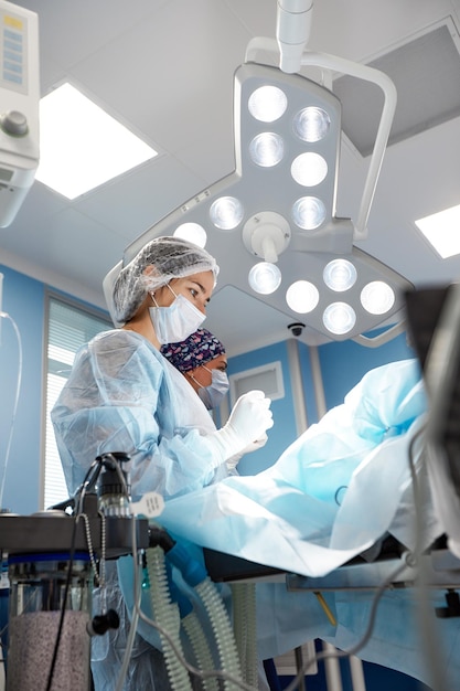 Konzentriertes chirurgisches Team, das einen Patienten in einem Operationssaal operiert