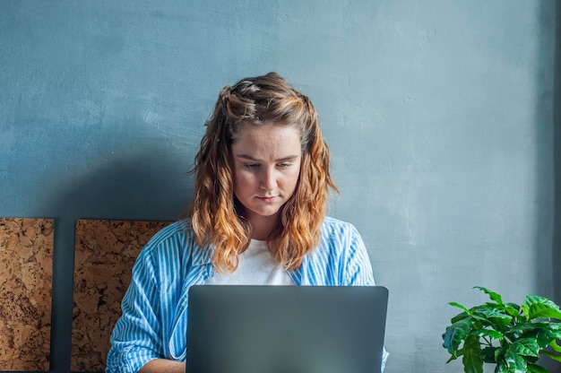 konzept arbeit von zu hause aus freiberuflich tätiges fernarbeitermädchen, das mit laptop auf dem bett sitzt und lächelnd arbeitet