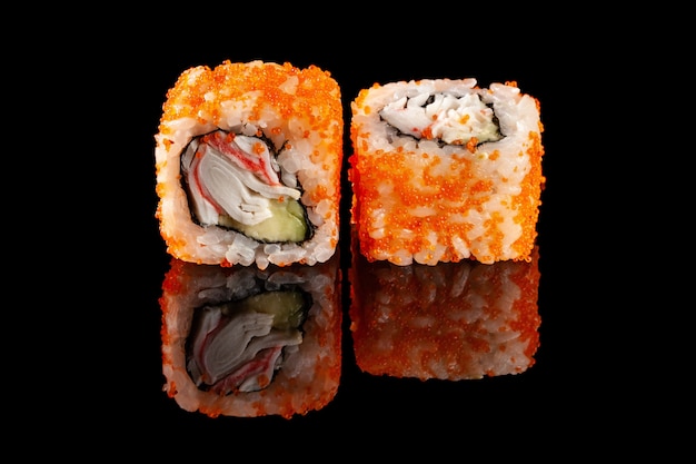 Konzept der asiatischen Küche. Zwei Rollen Sushi mit verschiedenen Füllungen auf einem schwarzen Hintergrund mit dem Alter für ein japanisches Menü für ein Café, Restaurant, Sushi-Bar.