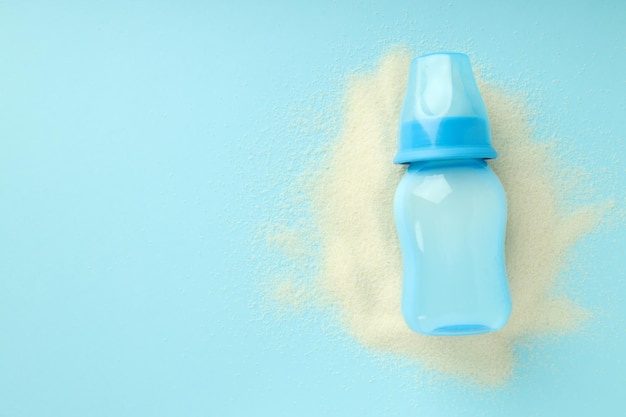 Konzept der Babynahrung mit Milchpulver auf blauem Hintergrund