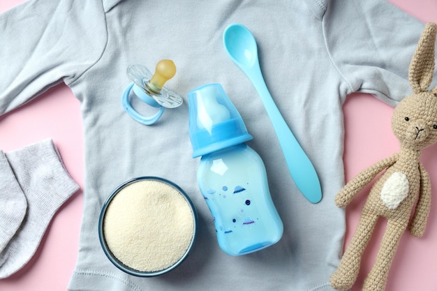 Konzept der Babynahrung mit Milchpulver auf rosa Hintergrund