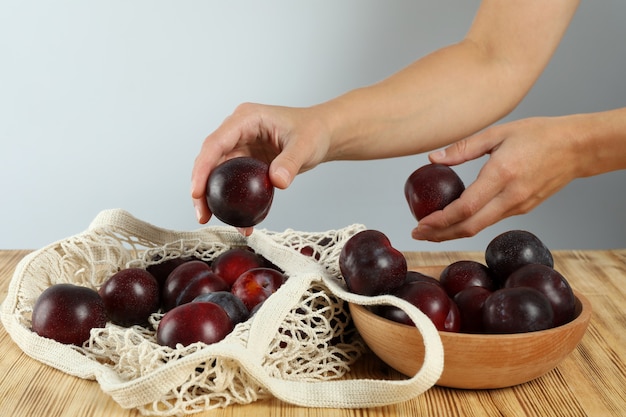 Konzept der Frucht mit Pflaumen auf Holztisch.