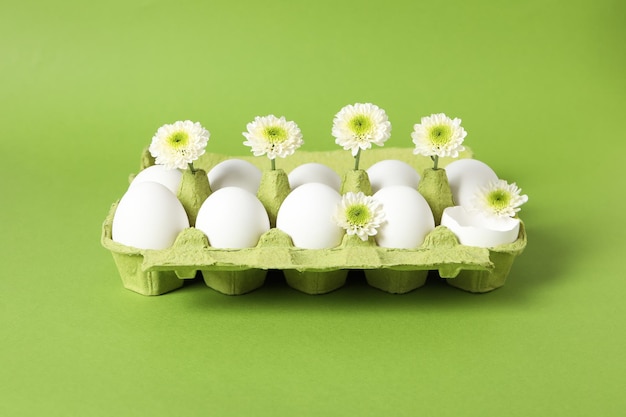 Konzept der Frühlingseier mit Blumen auf grünem Hintergrund