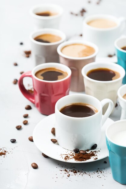 Konzept der Frühstücks-Entspannungszeit Verschiedene Kaffeetassen und Tassen auf einem gemütlichen Küchentisch