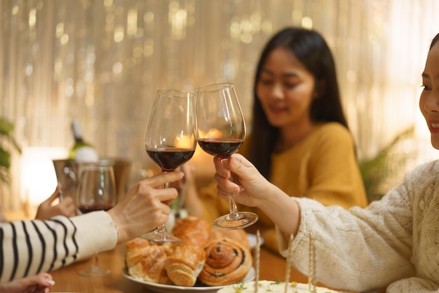 Konzept der Geburtstagsfeier Asiatische Mädchen klirren mit einem Glas Wein bei der Geburtstagsfeier zum Abendessen