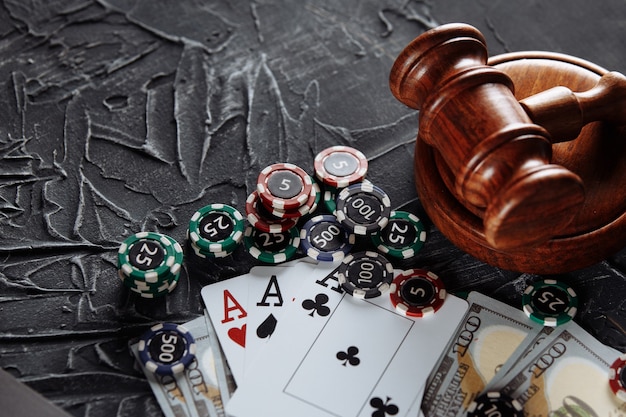 Konzept der gesetzlichen Regulierung des Glücksspiels, Justizhammer auf dem Hintergrund eines alten grauen Tisches.