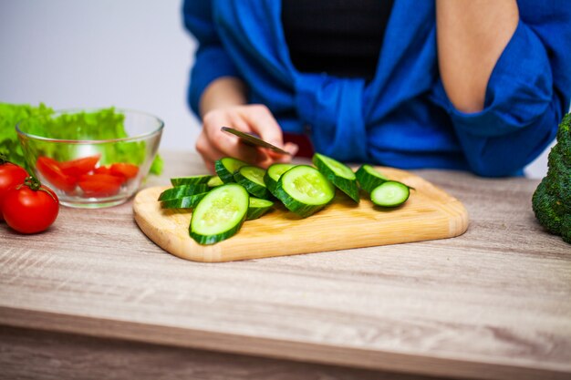 Konzept der gesunden Ernährung, Frau schneidet frisches Gemüse für Salat