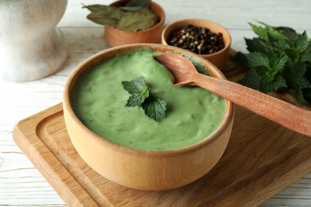 Konzept der gesunden Ernährung mit Brennnesselsuppe auf weißem Holztisch