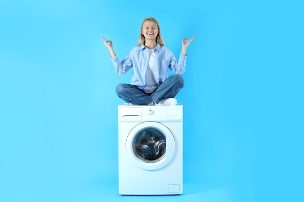 Konzept der Hausarbeit mit Waschmaschine und Mädchen auf blauem Hintergrund
