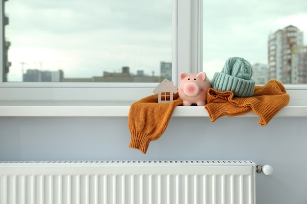 Konzept der Heizperiode mit Kleidung auf der Fensterbank.