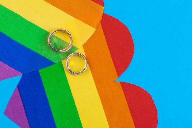 Konzept der homosexuellen Ehe mit Regenbogenflagge und -ringen