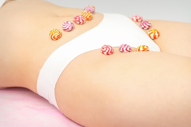 Konzept der intimen Enthaarung intime Waxing-Enthaarung Runde Bonbons, die in einer Reihe auf dem Intimbereich der weiblichen Bikinizone liegen, aus nächster Nähe