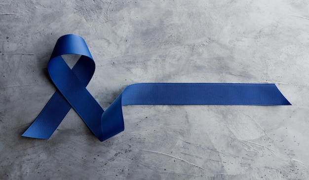Foto konzept der kampagne zur aufklärung über prostatakrebs männer im gesundheitswesen nahaufnahme einer blauen schleife, ansicht von oben