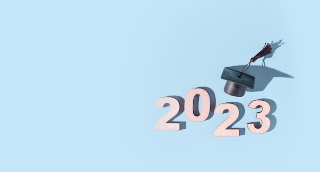 Konzept der Klasse 2023 Zahlen 2023 mit schwarzer abgestufter Kappe auf farbigem Hintergrund