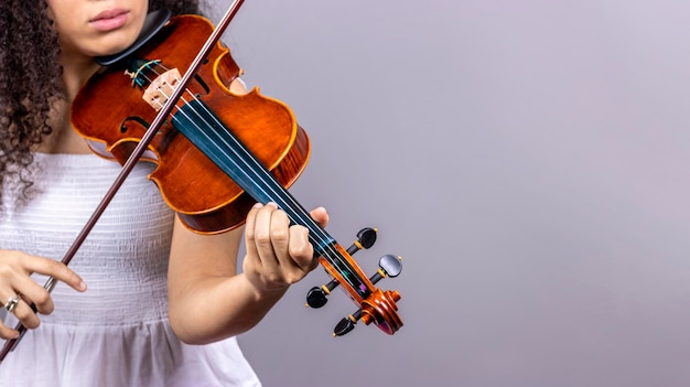 Konzept der klassischen Musik Copyspace Junges Mädchen spielt Violine auf grauem Hintergrund