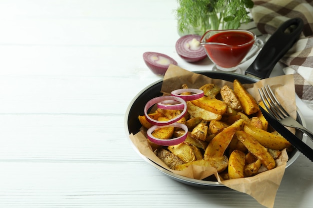 Konzept der leckeren Mahlzeit mit Pfanne der leckeren Kartoffelschnitze