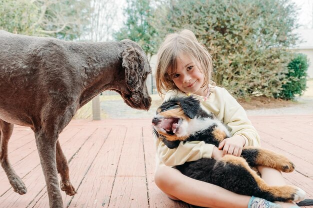 Foto konzept der liebe zu tieren und freundschaft mit haustieren entzückendes süßes kind mädchen mit welpen hund auf der veranda