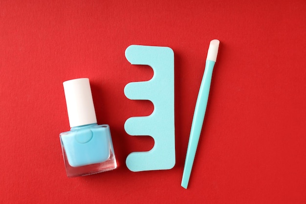 Konzept der Nagelpflege mit Manikürezubehör auf rotem Hintergrund