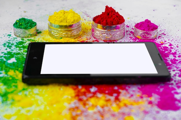 Konzept des indischen Festivals Holi Multi Color39s auf Etagen mit Telefon und Tablet