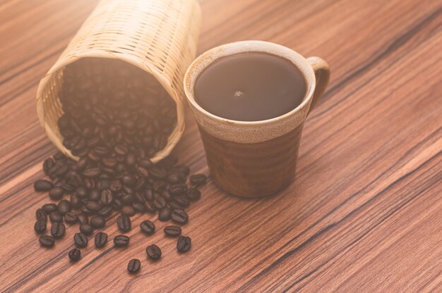 Konzept des Kaffeetrinkens Kaffeebohnen und Kaffeetassen stehen auf dem Tisch