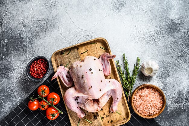 Konzept des Kochens des ganzen Poult. Zutaten Rosmarin, rosa Salz, Knoblauch und Kirschtomaten. Grauer Hintergrund. Draufsicht. Platz für Text