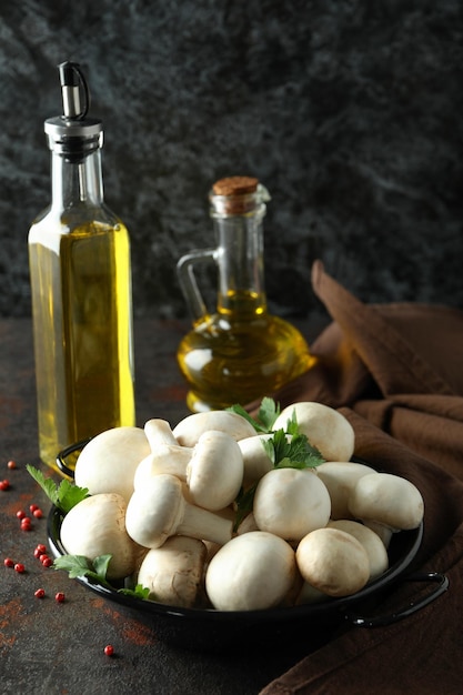 Konzept des Kochens mit Champignons auf dunklem strukturiertem Tisch