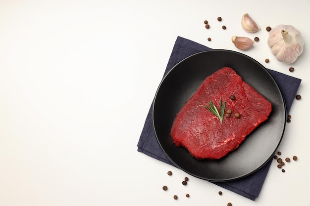 Konzept des Kochens mit rohem Steak auf weißem Hintergrund