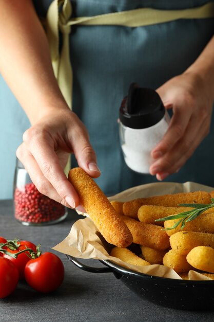 Konzept des Kochens von Käsesticks auf dunklem Tisch