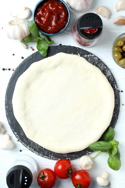 Konzept des Kochens von Pizza auf weißem Holzhintergrund