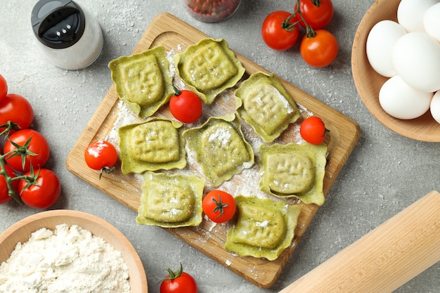 Konzept des Kochens von Ravioli auf grauem strukturiertem Hintergrund