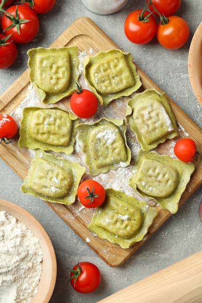 Konzept des Kochens von Ravioli auf grauem strukturiertem Hintergrund