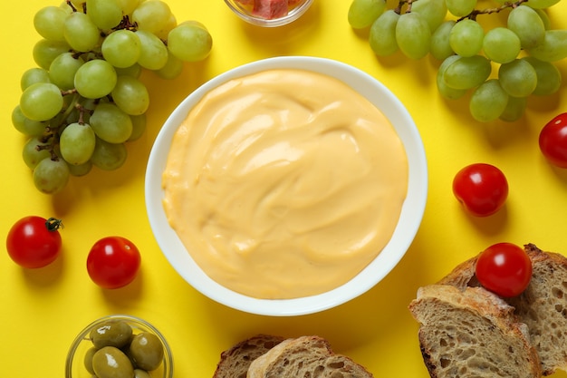 Konzept des köstlichen Essens mit Fondue auf gelbem Hintergrund