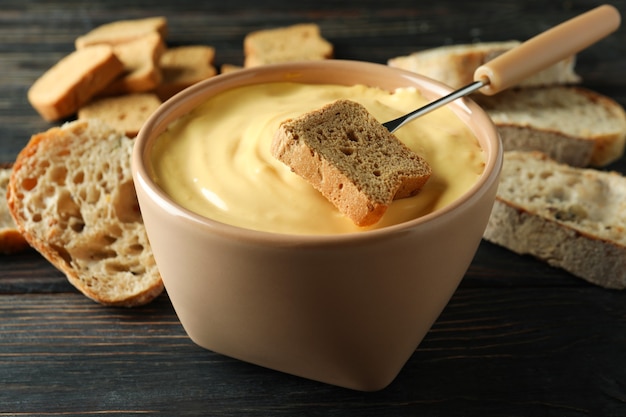 Konzept des köstlichen Essens mit Fondue auf Holztisch