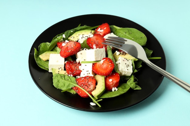 Konzept des leckeren Essens auf blauem Hintergrund Salat mit Erdbeeren