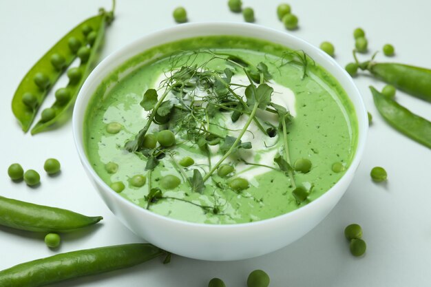 Konzept des leckeren Essens mit Erbsensuppe auf weißer Oberfläche