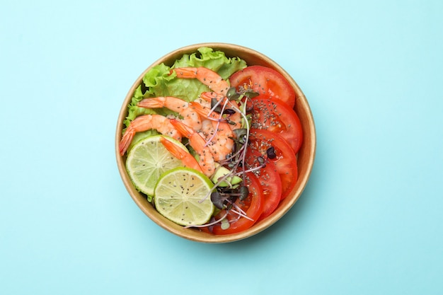 Konzept des leckeren Essens mit Garnelensalat auf blauem Hintergrund