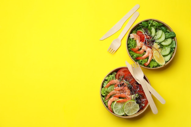 Konzept des leckeren Essens mit Garnelensalaten auf gelbem Hintergrund