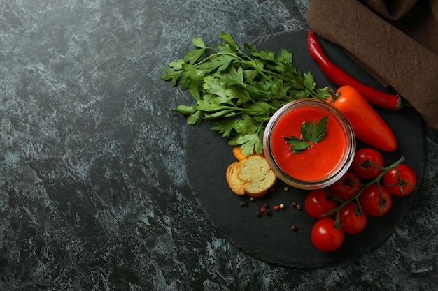 Konzept des leckeren Essens mit Gazpacho-Suppe auf schwarzem, rauchigem Hintergrund