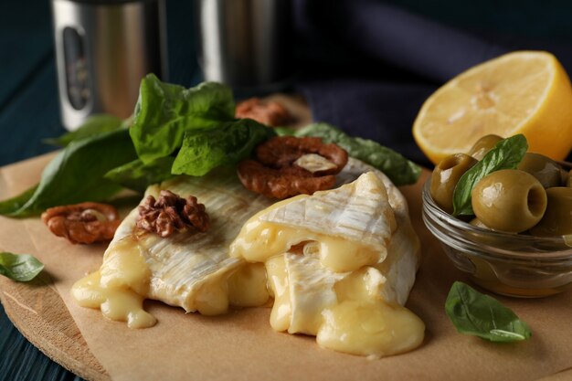 Konzept des leckeren Essens mit gegrilltem Camembert auf Holzhintergrund.