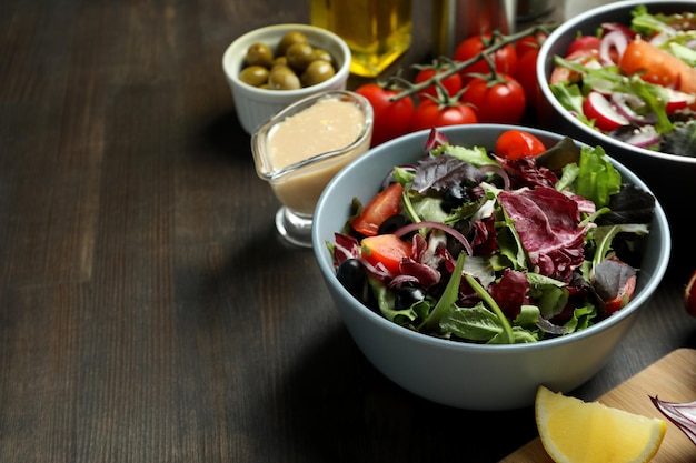 Konzept des leckeren Essens mit Gemüsesalat mit Tahini-Sauce auf Holzhintergrund