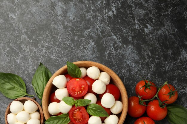 Konzept des leckeren Essens mit Mozzarella-Käse auf schwarzem rauchigem Hintergrund, Raum für Text