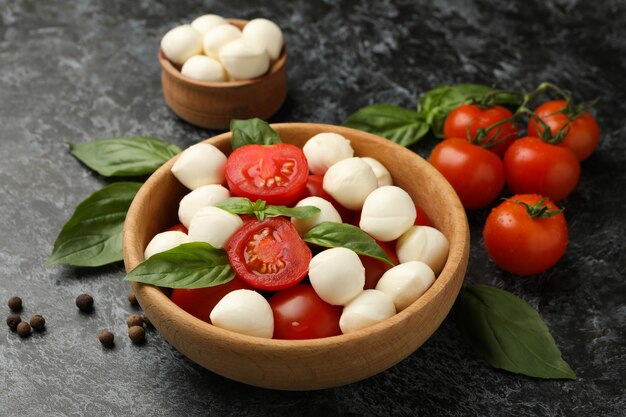 Konzept des leckeren Essens mit Mozzarella-Käse auf schwarzem rauchigem Hintergrund