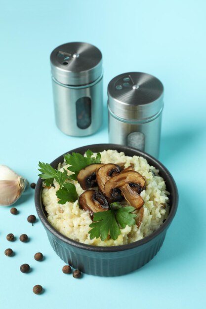 Konzept des leckeren Essens mit Risotto mit Pilzen auf blauem Hintergrund