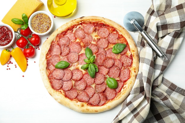 Konzept des leckeren Essens mit Salami-Pizza auf weißem Holzhintergrund